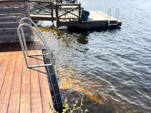 A wooden dock extending into a body of water with a metal ladder leading into the water. - 5 Star Holiday Home in Eksjo (Eksjo)