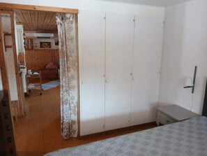 A bedroom with a wardrobe, a bed, a desk, and a curtain. - 5 Person Holiday Home in Lidsjoberg (Lidsjöberg)