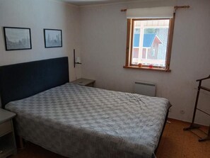 A bedroom with a bed, a nightstand, a window, and two framed pictures on the wall. - 5 Person Holiday Home in Lidsjoberg (Lidsjöberg)