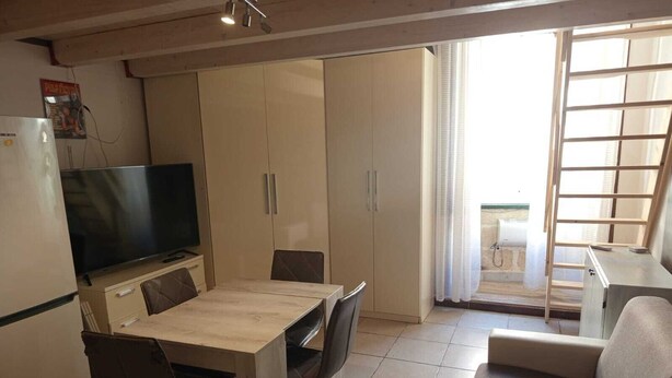 A compact living space with a kitchenette, a dining area, and a sofa. - Little apartment at André's a few minutes from the center of Lecce (Lecce)