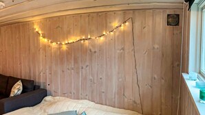 A room with a bed, a wooden headboard, and a string of lights. - 8 Person Holiday Home in Arla (Arla)