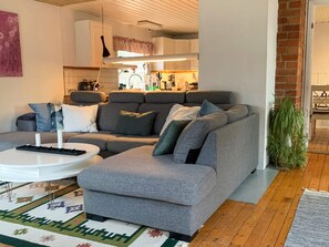 A modern living room with a grey sectional sofa, a white coffee table, and a patterned rug. - 8 Person Holiday Home in Arla (Arla)