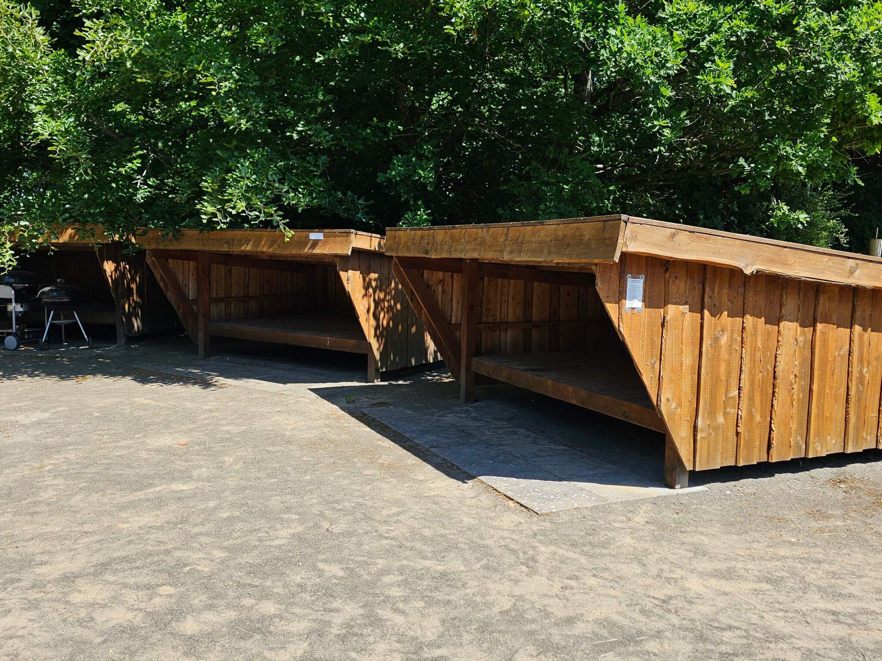 A row of wooden structures with benches, likely for outdoor seating or rest areas.