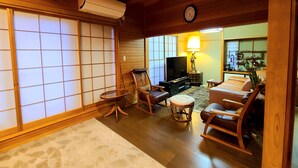 A traditional Japanese-style living room with tatami flooring, a television, and a wooden ceiling. - Maple House - Kawaguchiko Otsuki - 10 people or more (大月市)