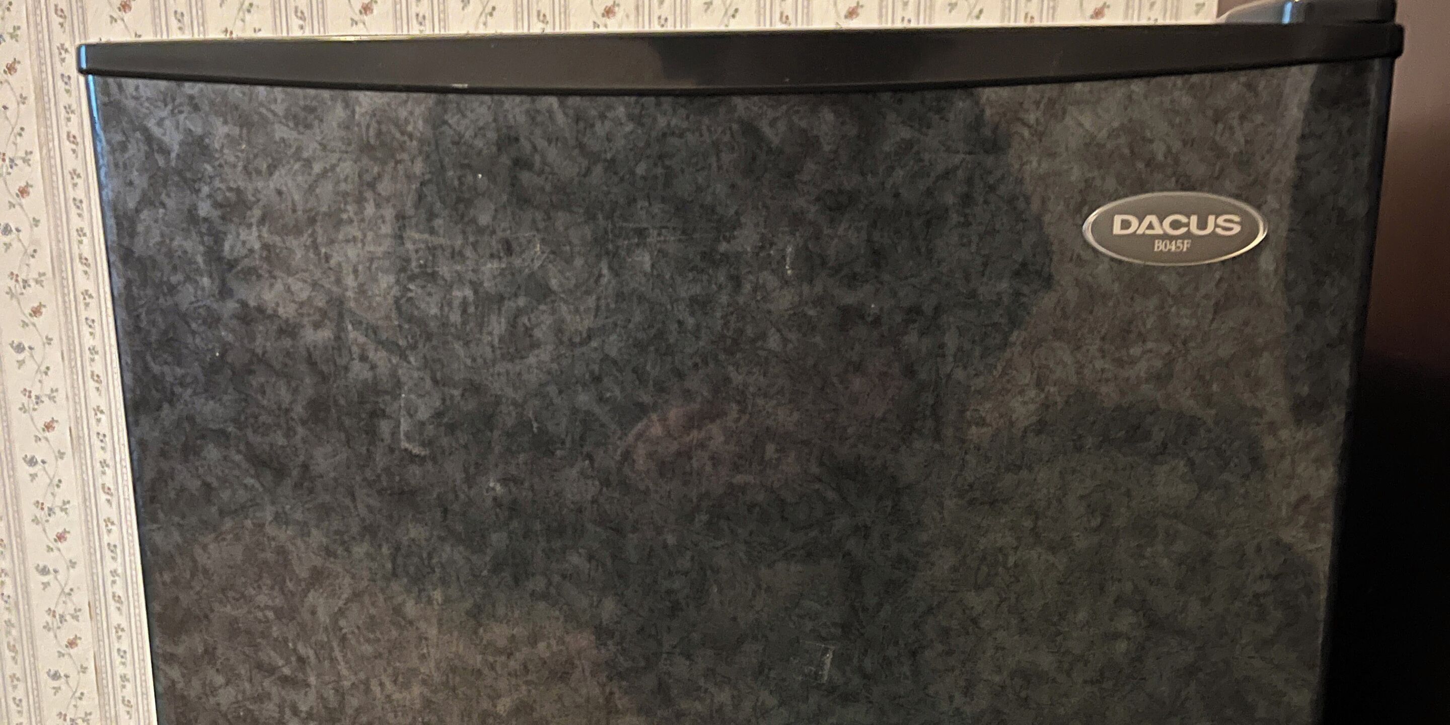 A refrigerator with a dark textured exterior and a brand label 'DACUS B045F'.