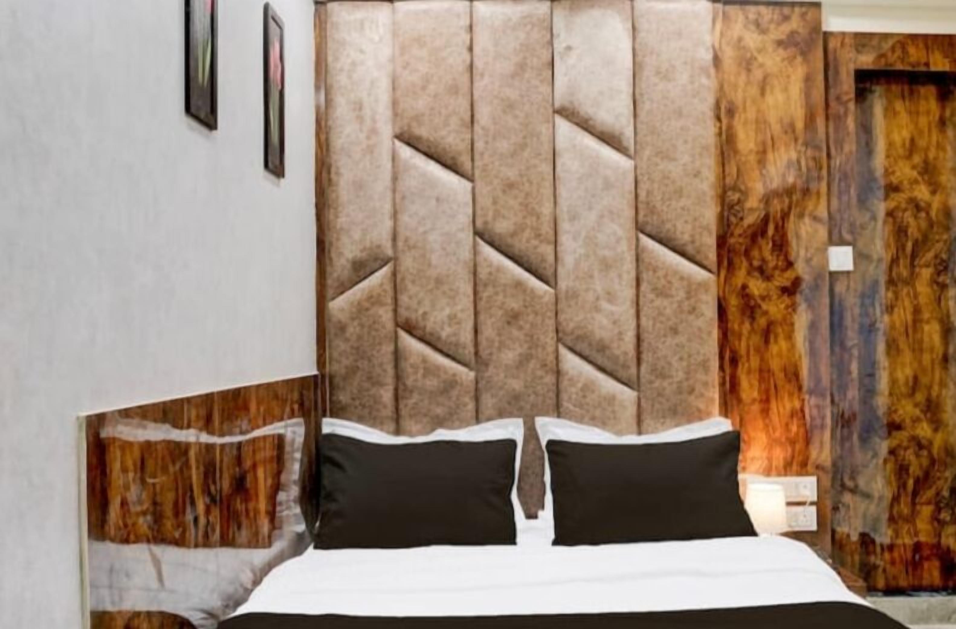A bedroom with a large bed, a wooden headboard, and a nightstand.
