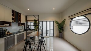 Une cuisine moderne dotée d’un îlot central, de tabourets de bar et d’une grande fenêtre.