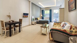 Ein modernes Wohnzimmer mit Esstisch, Sofa und Bett.