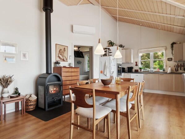 Een moderne keuken met een centraal eiland, houten stoelen en hanglampen.