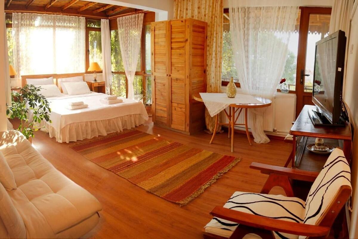 Un dormitorio acogedor con cama, sofá, una mesita y televisión.