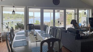 Comedor con vista al lago, una araña y un ventanal grande.