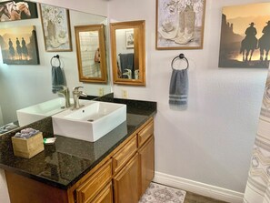 A bathroom with two sinks, wooden cabinets, and a large mirror. - 🌵 “Mountain View 2BR Country Home -Netflix – Spacious (Hesperia)