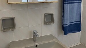 A bathroom with a white sink, a mirror, and a towel rack. - Corfu Town Flat (Kerkira)