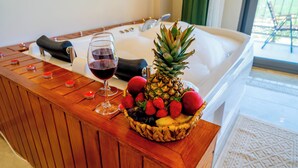 Ein Holztresen mit Obstkorb, einem Weinglas und einer Badewanne.