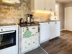 A kitchen with a built-in oven, a coffee maker, and a dishwasher. - 6 Person Holiday Home in Kristdala (Kristdala)