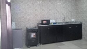 A kitchen with a granite countertop, a microwave, and a sink. - YP-MADE SUPERB VILLA featuring 2 and 1-bedroom apartments, (Ibeju Lekki)
