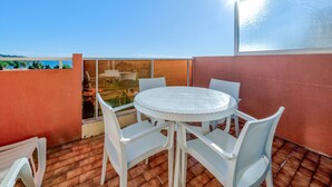A round table with white chairs on a tiled patio. - Studio for 4 with Wi-Fi, sea view, Roquebrune-Cap-Martin (Roquebrune-Cap-Martin)