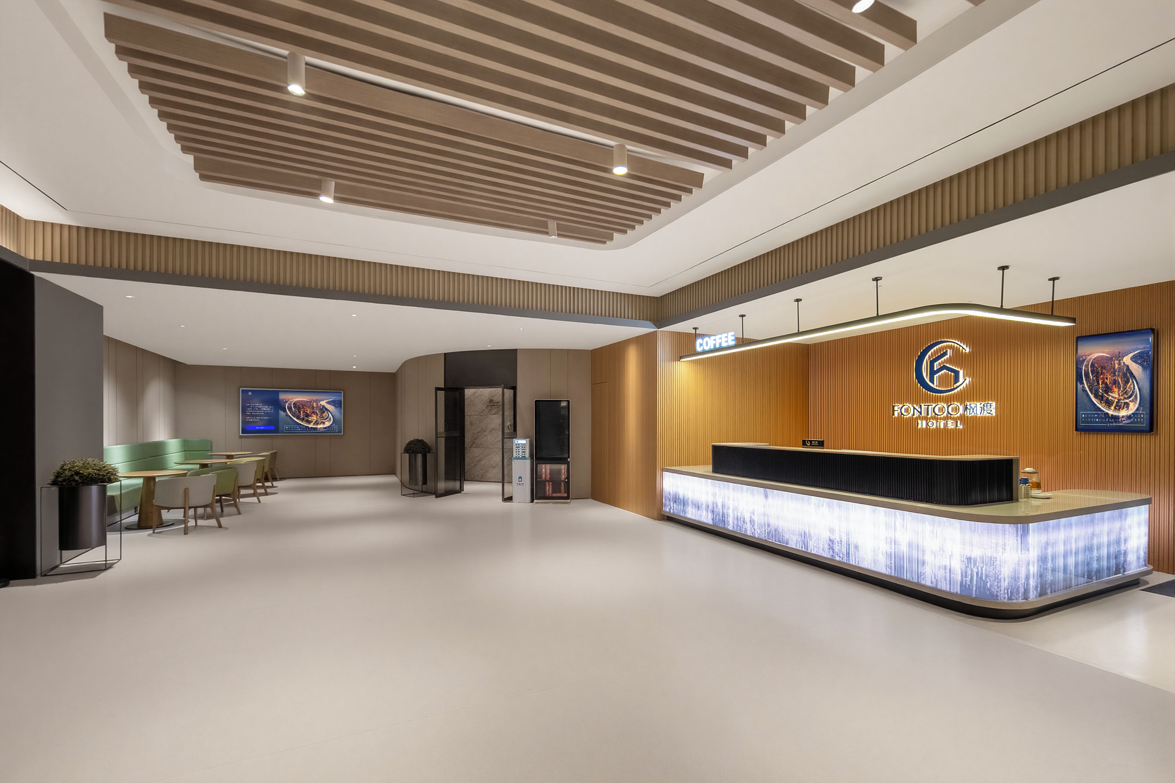 Ein Hotel-Empfangsbereich mit modernem Design, einer Rezeption und einem digitalen Bildschirm, der Informationen anzeigt.