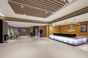 A hotel reception area with a modern design, a reception desk, and a digital screen displaying information. - Fengdu Hotel (Shanghai Lujiazui Baibaiban Branch) (Shanghai)