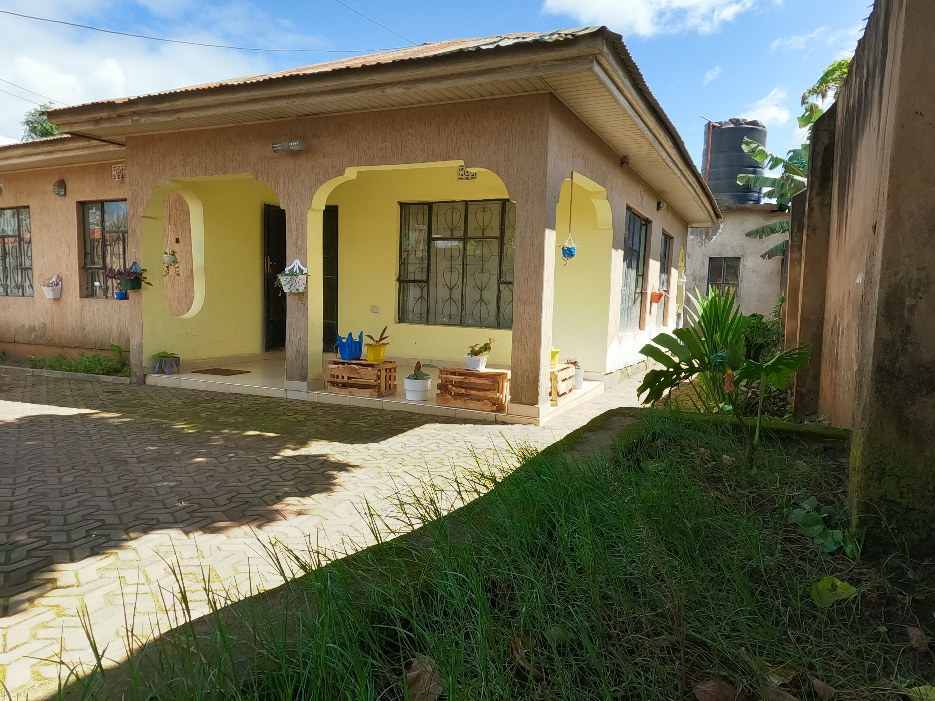 A two-story building with a tiled entrance and a small porch area.