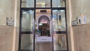 A hotel entrance with a glass door, a tiled floor, and a marble wall. - Hotel Amadeus (Rome)