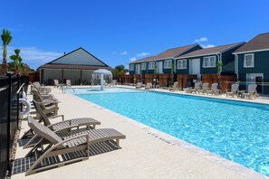Une piscine avec des chaises longues et un espace abrité.