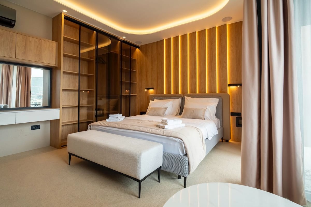 Un dormitorio moderno con una cama grande, un armario empotrado y una mesita de noche.