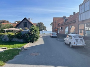 A street view with a vintage car parked on the side, a manhole cover on the road, and a building with a visible window. - 5 Person Holiday Home in Stehag (Stehag)