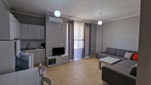 Un appartement moderne comprenant une cuisine, un coin repas et un salon.