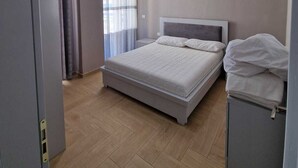 Une chambre à coucher avec un lit, une armoire et un luminaire au plafond.