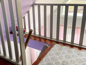 A wooden staircase with a purple mat at the bottom, leading to a room with a window. - 6 Person Holiday Home in Hemse (Hemse)