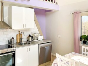 A compact kitchen with a dishwasher, a coffee maker, and a toaster. - 6 Person Holiday Home in Hemse (Hemse)