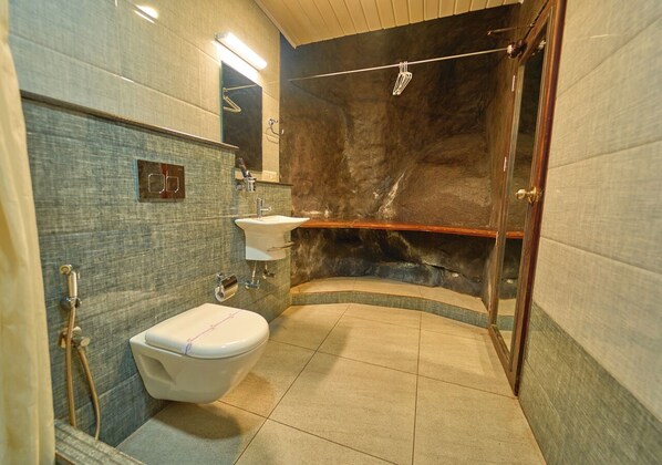 A bathroom with a toilet, sink, and shower area. - Niyatma Resort Wayanad by VOYE HOMES (Vythiri)