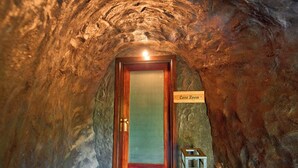 Een tunnelachtige kamer met een houten deur waarop 'Grotkamer' staat.