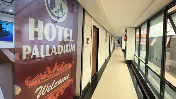 A hallway with a sign for Hotel Palladium and a welcome sign. - Hotel Palladium (Surat)