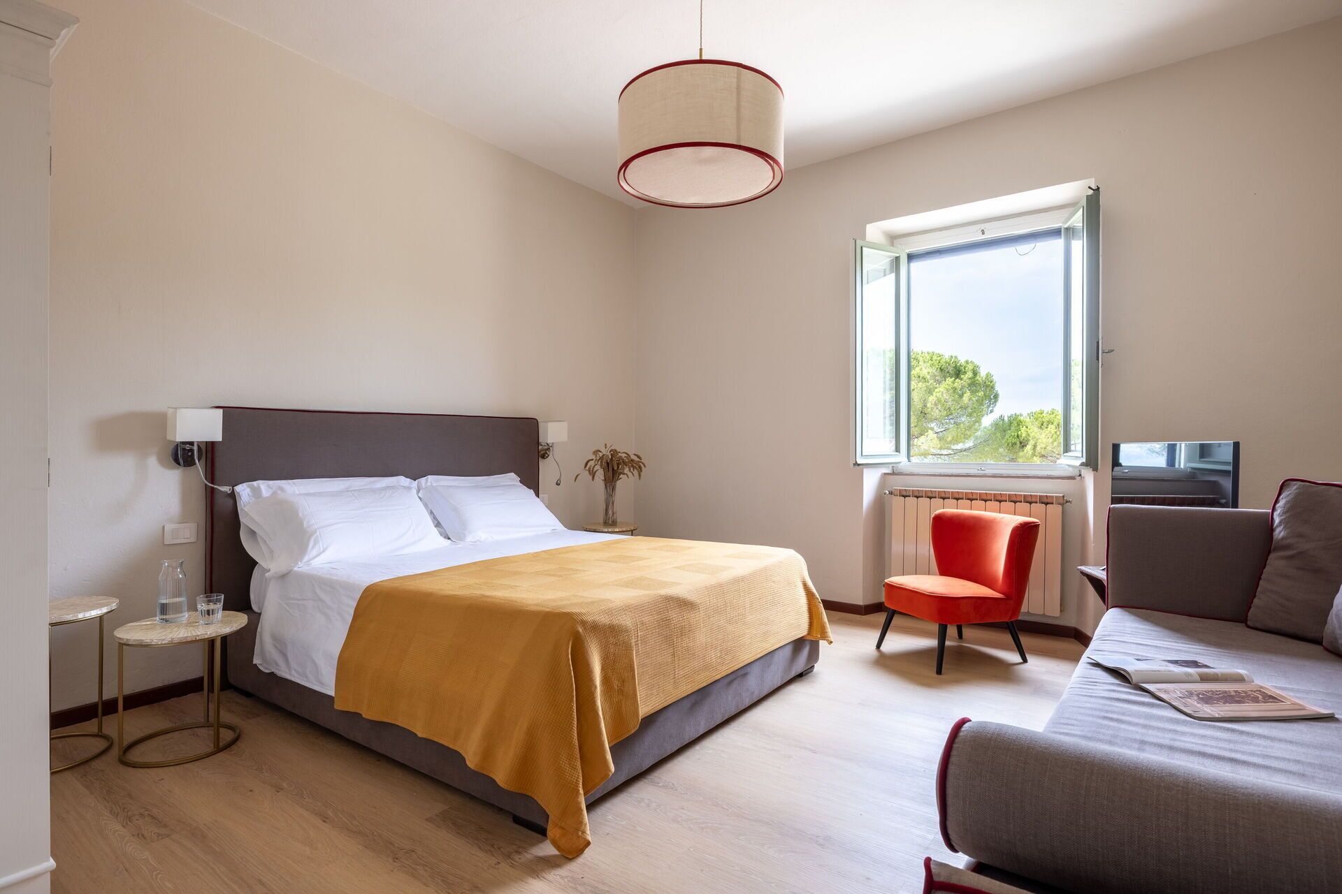 Ein Schlafzimmer mit Bett, Stuhl, Tisch und Fenster mit Blick.