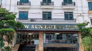 Un hotel de varios pisos con un cartel llamativo que dice "NEW SUN HOTEL".