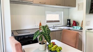 Una cocina compacta con comedor, estufa, pileta y ventana.