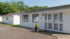 A row of white mobile homes with large windows and a gravel driveway. - Wonderful private villa for 4 guests with WIFI, TV and patio (Bodmin)