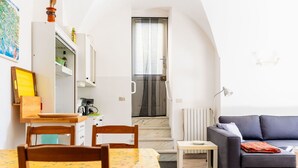 A compact living space with a dining area, kitchenette, and a sofa.