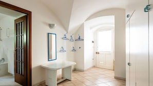 A bathroom with a white sink, a mirror, and several wall-mounted towel racks.