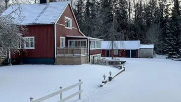 A red barn with a covered porch and a garage.