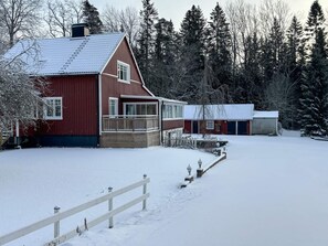 Une grange rouge avec un porche abrité et un garage.