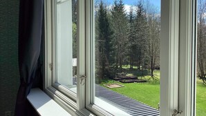 A window with a view of a garden and trees.