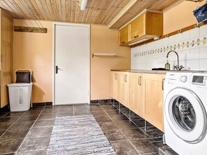 A laundry room with a washing machine, a drying rack, and a door. - 4 Star Holiday Home in Tvarred (Tvärred)