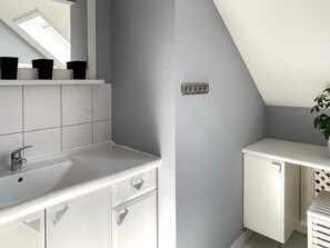 A modern bathroom with a skylight, white cabinetry, and a plant. - 4 Star Holiday Home in Tvarred (Tvärred)