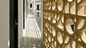 A corridor with a patterned wall and a tiled floor. - Bali Loop Coliving & Coworking (Mengwi)