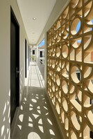Un pasillo con pared decorada y suelo de baldosas.