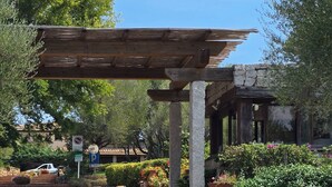 Un mur de pierres sur lequel est apposée une enseigne indiquant « Ladunia », ainsi qu’une structure en bois formant une pergola.