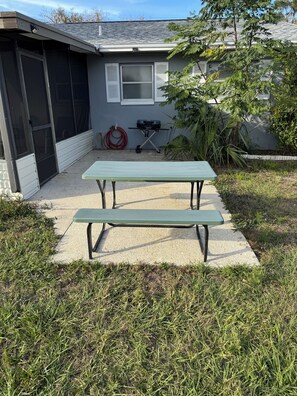 A patio area with a green picnic table and a barbecue grill. - 3-bedroom with Lakeview, Free Kayaks and Game Room, Pets Allowed, Lanai & Grill (Inverness)